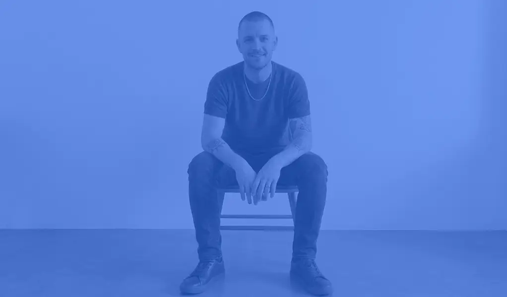 an image of James from Rokitsite sitting on a chair with a medium blue coloured overlay