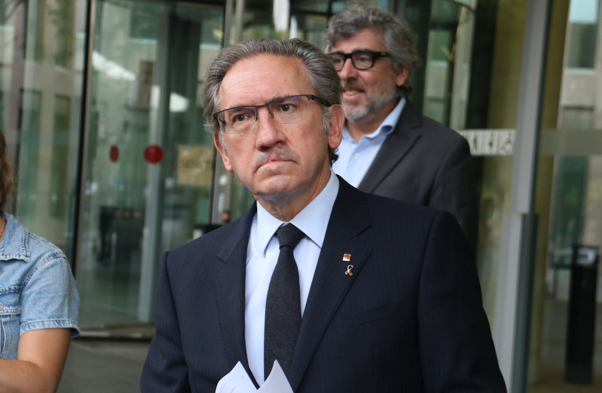 El conseller d'Economia, Jaume Giró, a la porta de la Ciutat de la Justícia, amb el seu advocat, Jordi Pina, darrere.