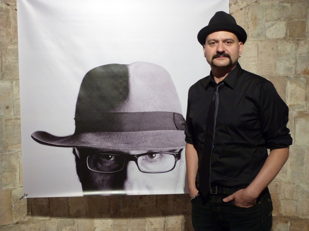 Carles Mercader amb una de les imatges de la seva nova exposició: un retrat del poeta Vicenç Altaió