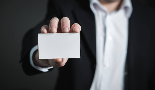 An image of a person showing a visiting card for your future career and establish your personal career path by buying one of the Abide AutomationX Global Institute courses.