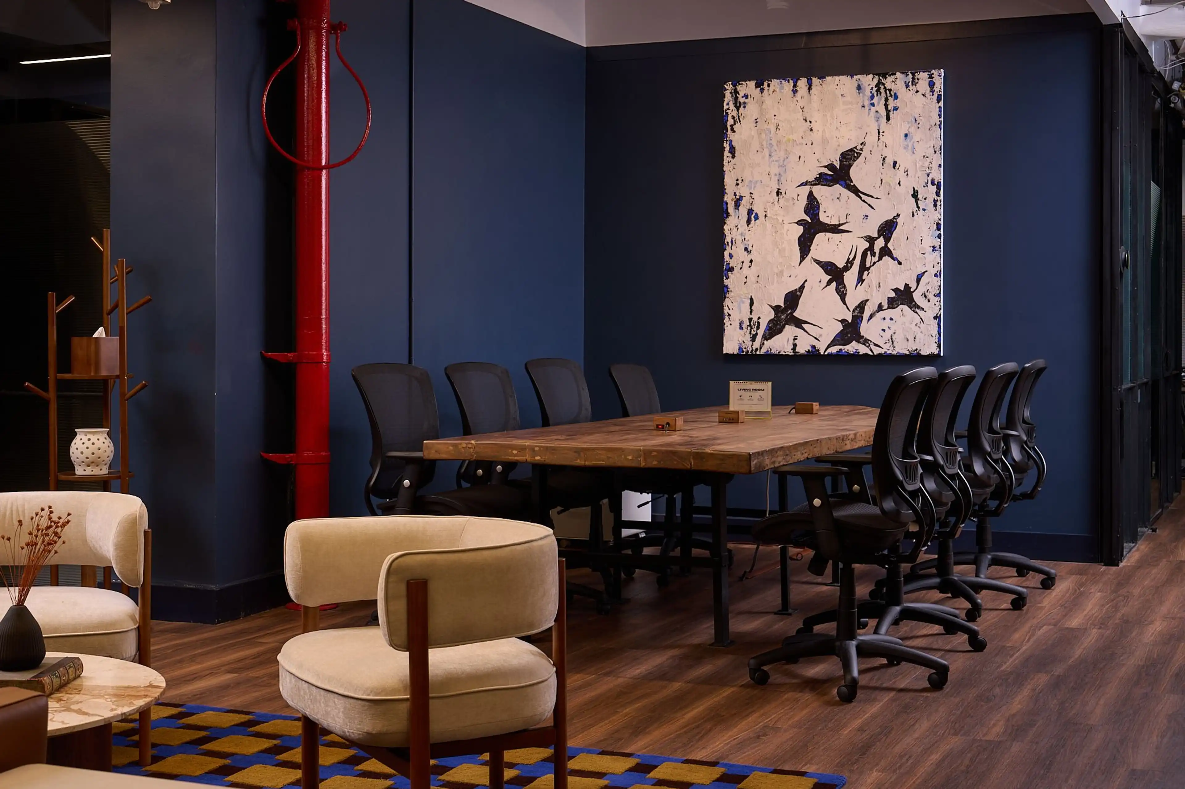 Flatiron coworking suite with tan leather sofa, white chairs, and greenery for a refined look.