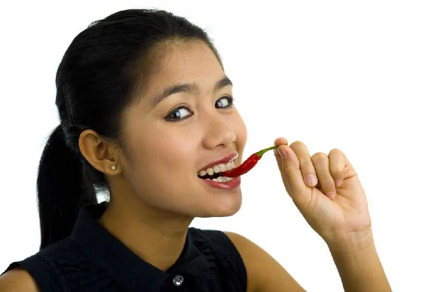 Eating spicy food can produce a variety of physiological reactions, such as a tingling in the tongue and lips, as well as sweating.