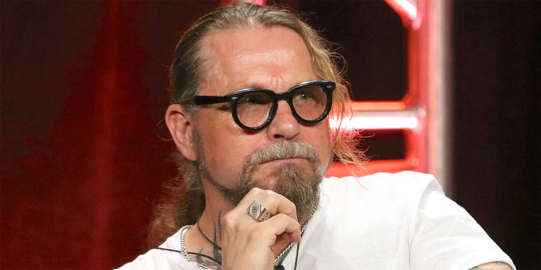 Kurt Sutter sitting and looking at something.