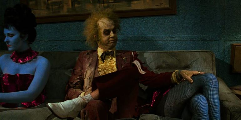 Beetlejuice (Michael Keaton) feels up dismembered legs in the Neitherworld waiting room at the end of Beetlejuice.
