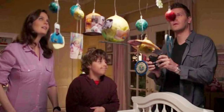 Parker Booth (Ty Panitz), Bones (Emily Deschanel), and Seeley (David Boreanaz) looking at the mobile Parker made in Bones.