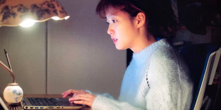 A young woman on a computer in the K-drama in Cheese in the Trap