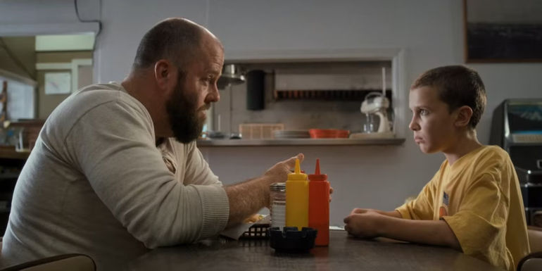 Eleven sits in a diner in Stranger Things