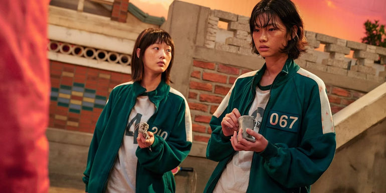 HoYeon Jung as Kang Sae-byeok and Lee Yoo-mi as Ji-yeong in Squid Game playing marbles