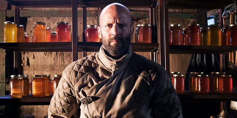 Jason Statham in front of jars of honey in The Beekeper movie