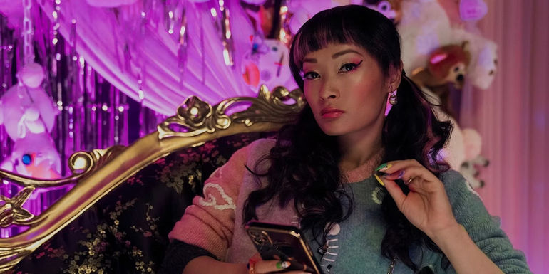 May Song sitting with her phone in Brothers Sun