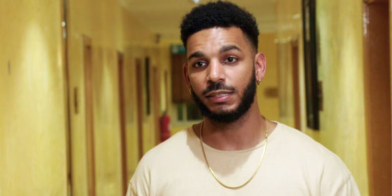 Jamal Menzies from 90 Day Fiance franchise in beige shirt in hallway