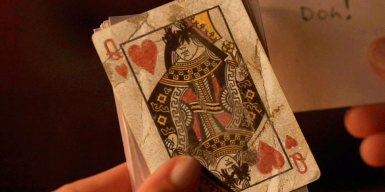 Lottie holding the Queen of Hearts on Yellowjackets