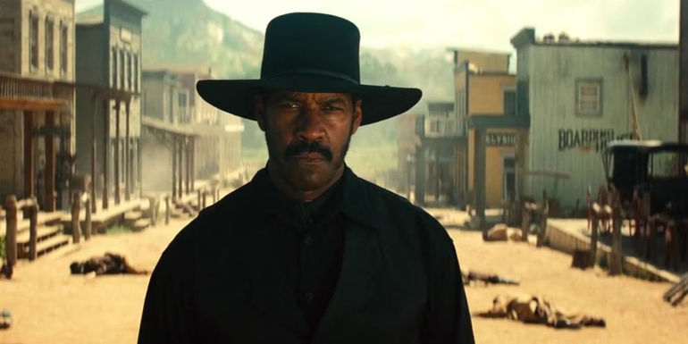 Denzel Washington as Sheriff Sam Chisholm standing in an Old West street in 2016's The Magnificent Seven.