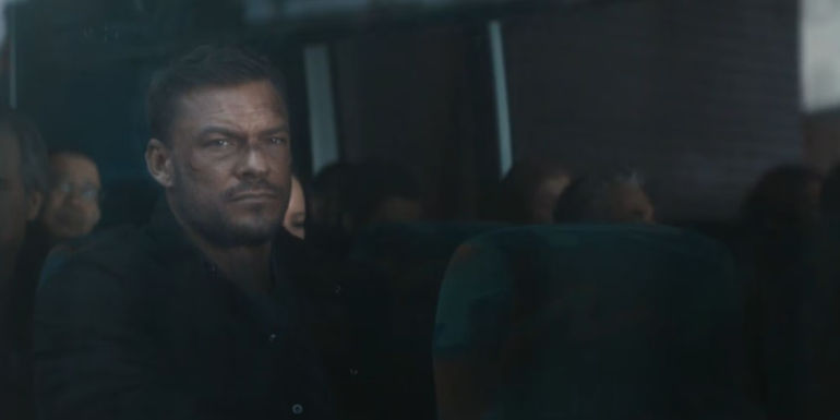 Alan Ritchson as Reacher sitting on the bus and staring out the window