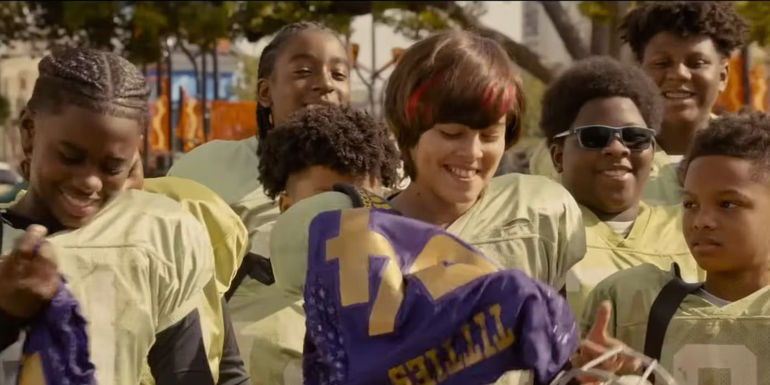 Caleb Dixon as Dwayne and Adan James Cabrillo as Tony surrounded by teammates in The Underdoggs.