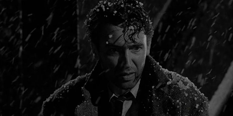 George Bailey standing on a bridge in the snow in It's a Wonderful Life