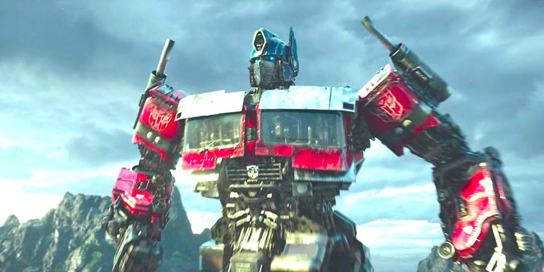 Optimus Prime posing heroically before a mountain range in Transformers: Rise of the Beasts