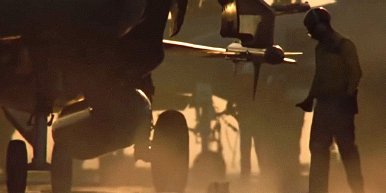 A navy worker standing beside the A-6 plane in Top Gun.
