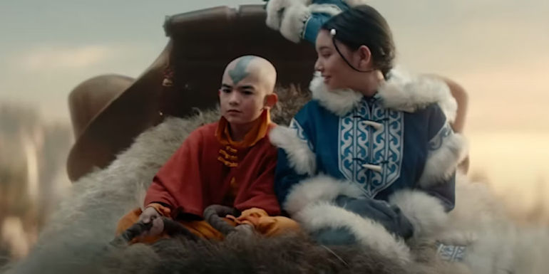 Gordon Cormier as Aang and Kiawentiio as Katara ride Appa in Avatar: The Last Airbender.