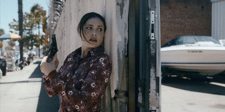 June holding a gun in Griselda