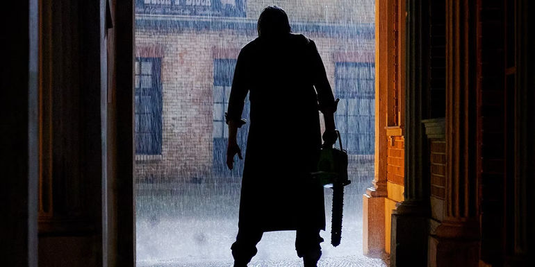 Leatherface stands in a doorway in The Texas Chainsaw Massacre 2022