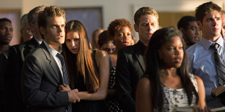 Stefan holding Elena up next their friends at a memorial service in The Vampire Diaries