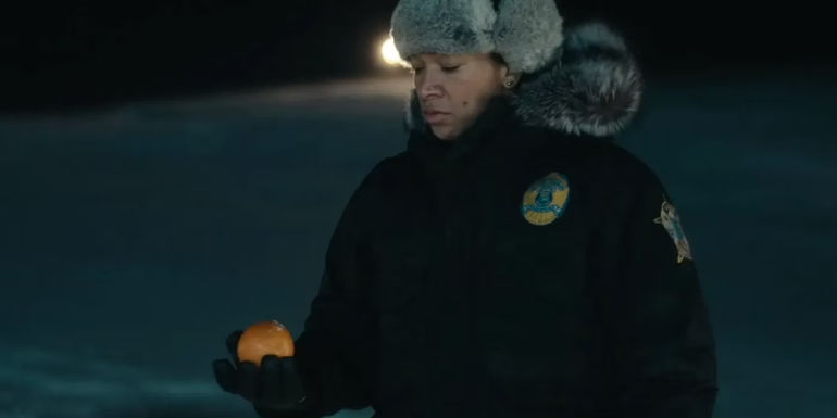 Navara with an orange in her hand in true Detective