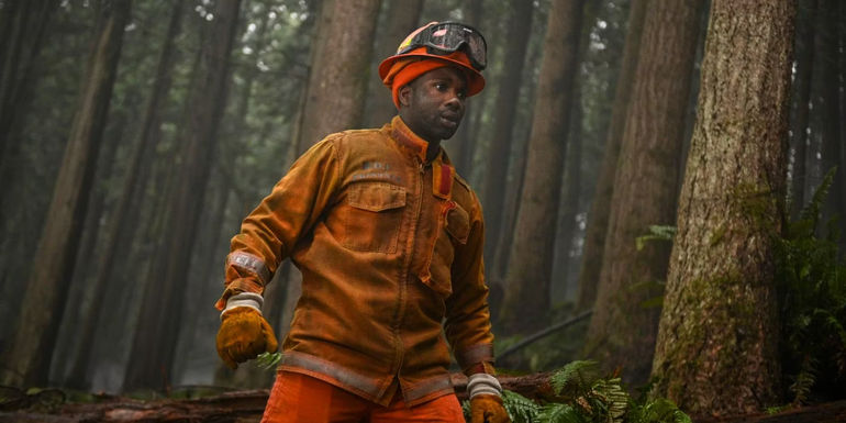 Jake Crawford (Jordan Calloway) walking through the forest in a fireman's uniform in Fire Country.