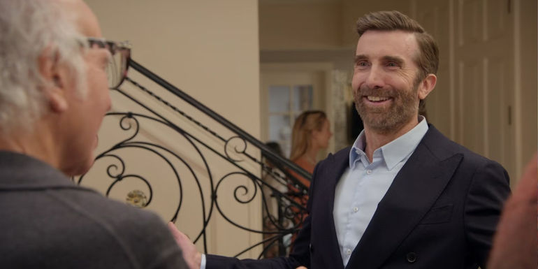 Michael Fouchay smiling in Curb Your Enthusiasm