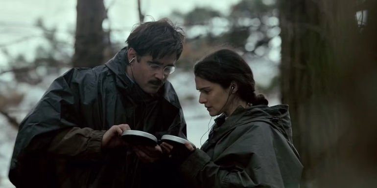 Colin Farrell and Rachel Weisz looking at devices in the forest in The Lobster