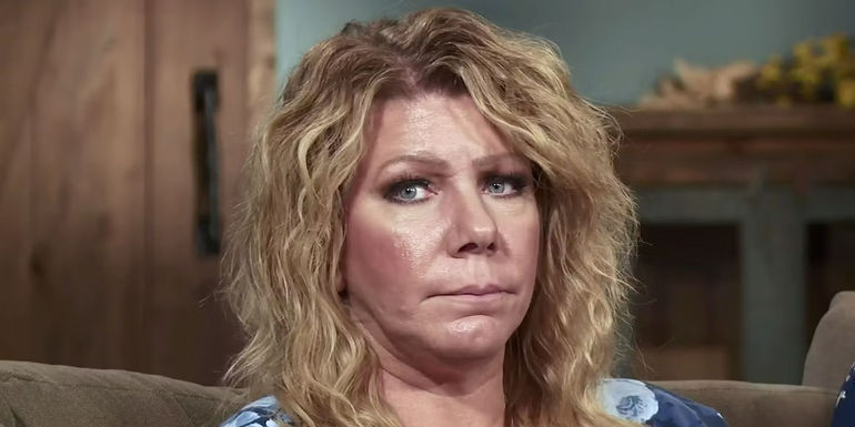 Sister Wives star Meri Brown sitting on couch looking serious