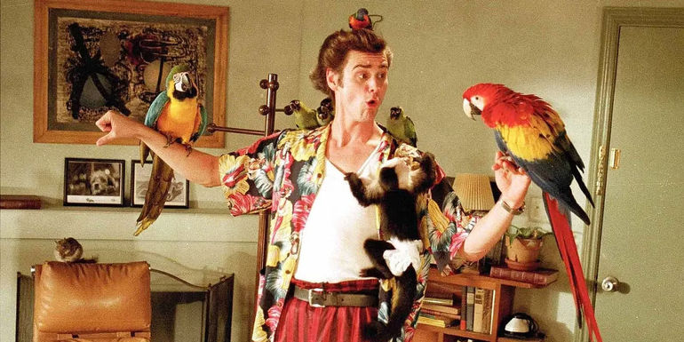 Jim Carrey with various animals hanging off him in Ace Ventura: Pet Detective