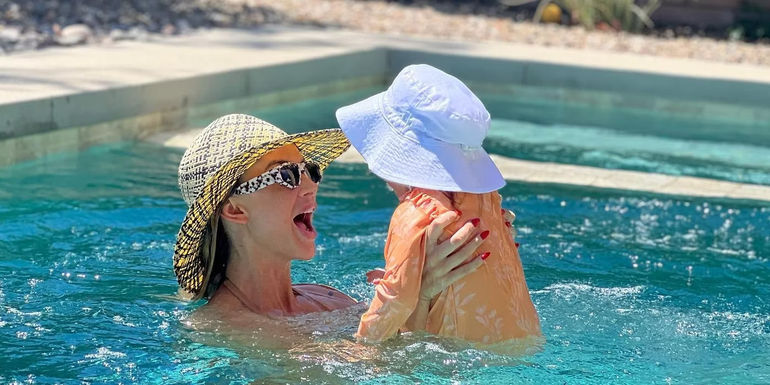 Lala Kent from Vanderpump Rules smiles and lifts daughter Ocean in the swimming pool.