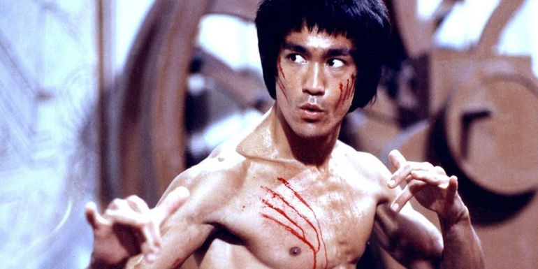 Bruce Lee as Lee in a martial arts stance and bleeding from several wounds in Enter the Dragon