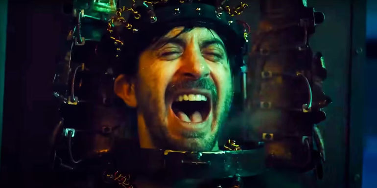 A man screaming with his head in an electrical contraption in Saw X.