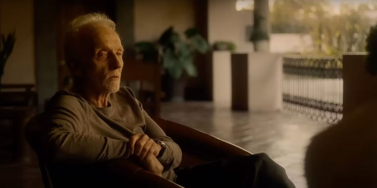 Tobin Bell sits in a chair in a Mexican villa in Saw X