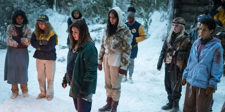 The survivors standing in the snow looking at something off screen in Yellowjackets season 2 episode 2.