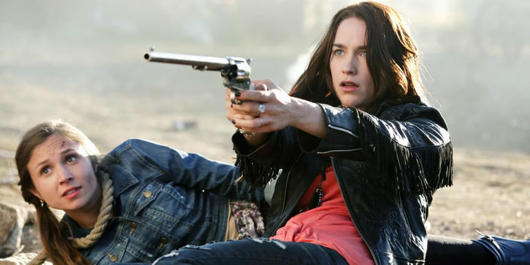 Wynonna with a gun and Waverly on the ground behind her in Wynonna Earp