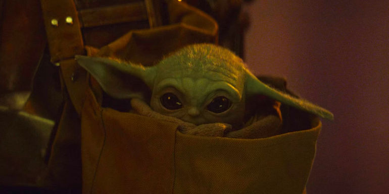 A shy Grogu hides inside his robes and his bag in The Mandalorian season 1 finale
