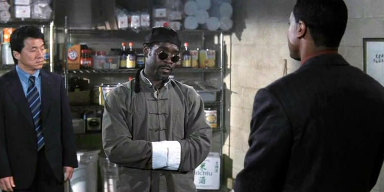 Kenny (Don Cheadle) standing between Carter (Chris Tucker) and Lee (Jackie Chan) in a kitchen in Rush Hour 2.