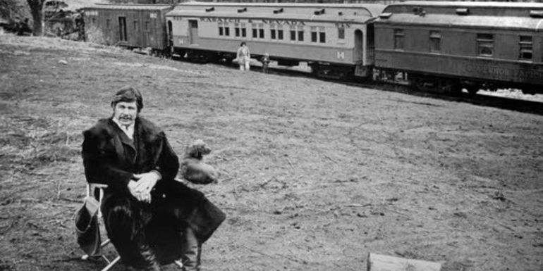 Deakin sitting in front of a train in Breakheart Pass