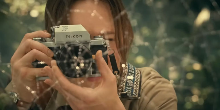 Kerry Bishe as Constance Webb in Madame Web taking a photo with a camera