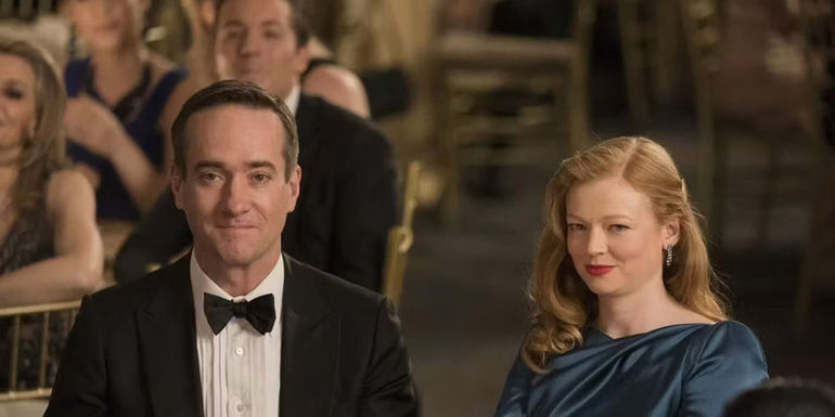 Tom and Shiv smiling while at a dinner party in Succession