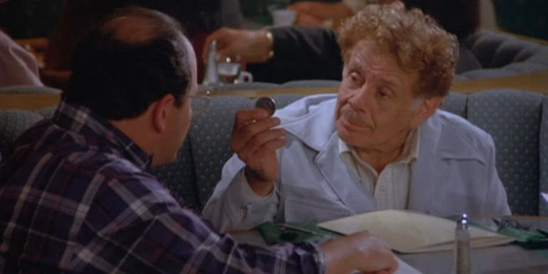 Frank showing George a coin in Seinfeld