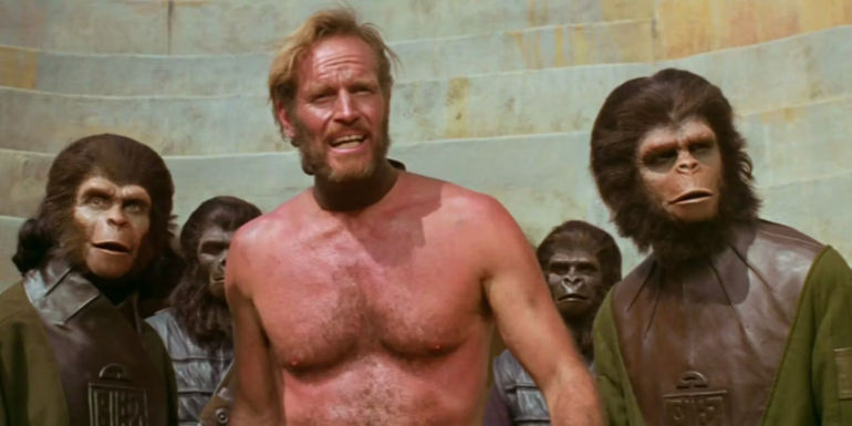 Charlton Heston as George Taylor is surrounded by apes in Planet of the Apes.