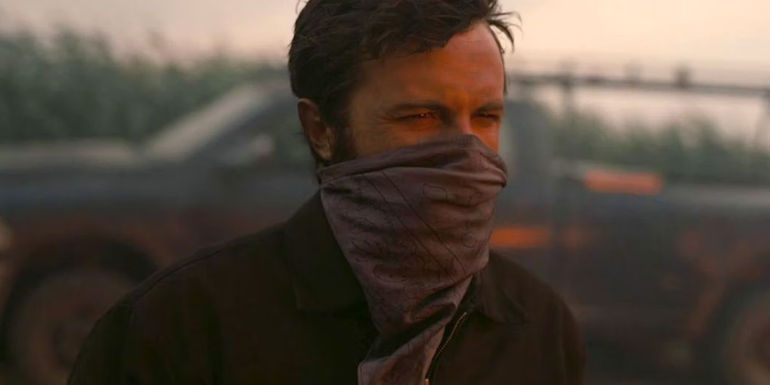 Tom (Casey Affleck) with a bandana around his nose and mouth in Interstellar.