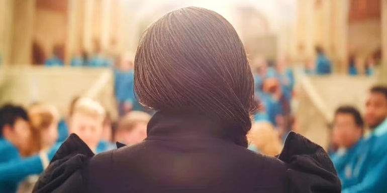 Cynthia Erivo as Elphaba approaching Shiz from the back in Wicked