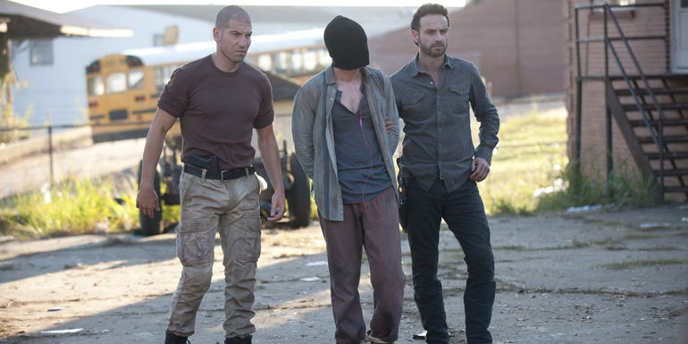 Rick (Andrew Lincoln) and Shane (Jon Bernthal) bringing the abducted Randall (Michael Zegen) with them in The Walking Dead 