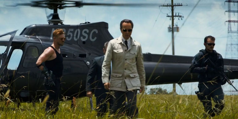 Richard E Grant walking through a field in Logan