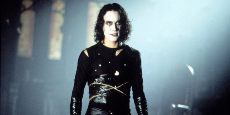 Brandon Lee as Eric Draven in full costume in an abandoned church in The Crow